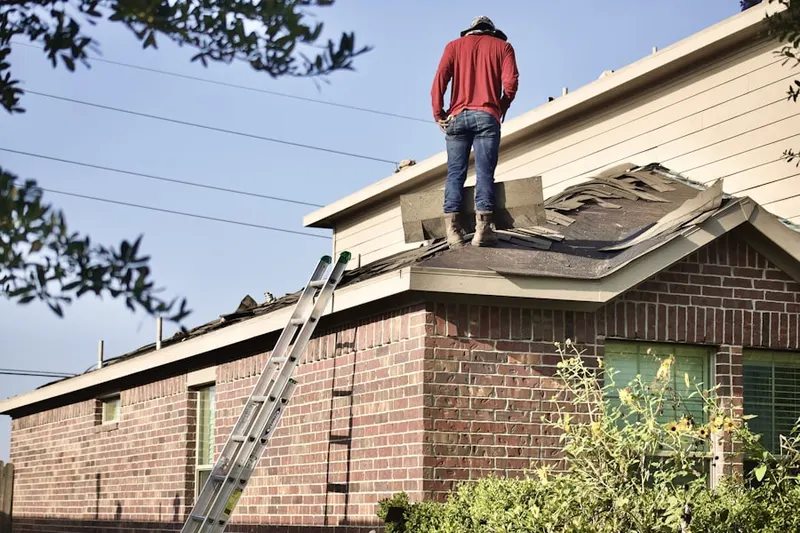 Professional roofer working on a residential roof in Texas AandM University